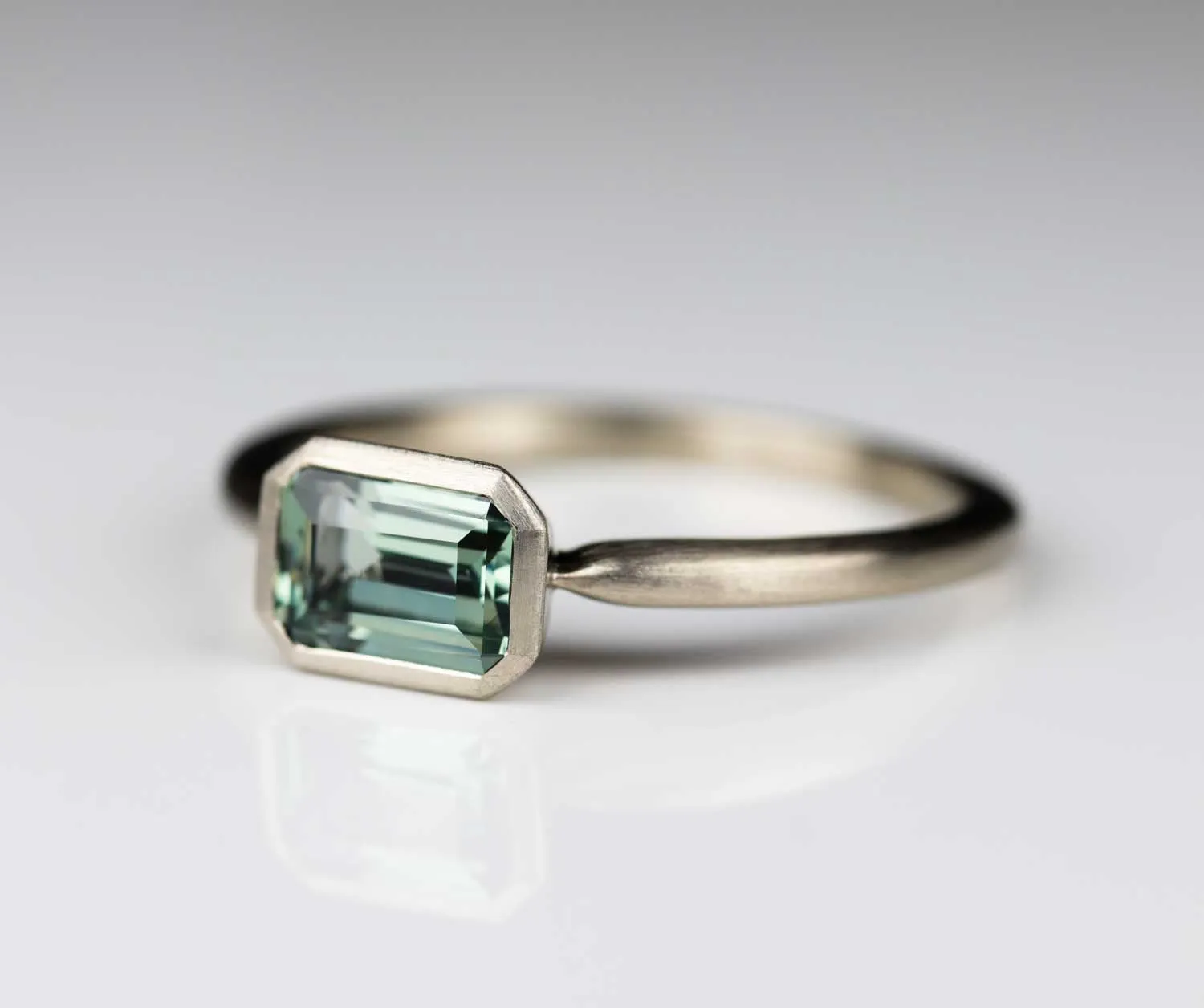 East West Bezel Solitaire Engagement Ring with Lab-grown Light Green Sapphire